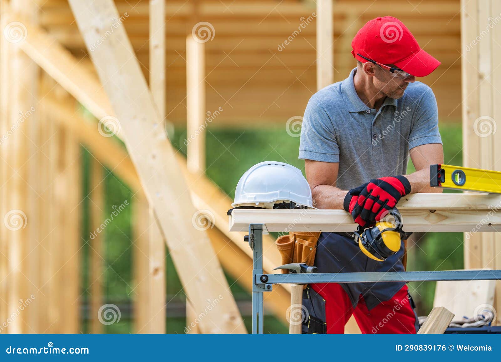 construction worker in front of newly developed wooden skeleton house frame