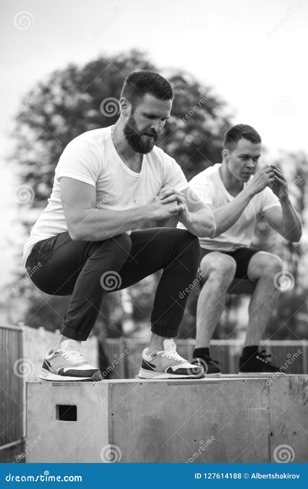 caucasian male athletic friends doing box jump outdoor on top of the mountain.