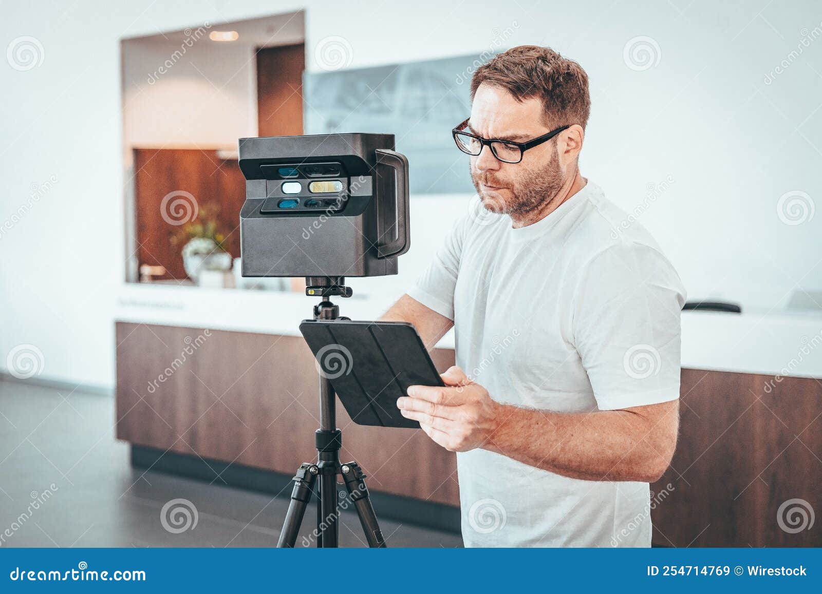 caucasian man with matterport camera and tablet doing 3d scan virtual tour indoors
