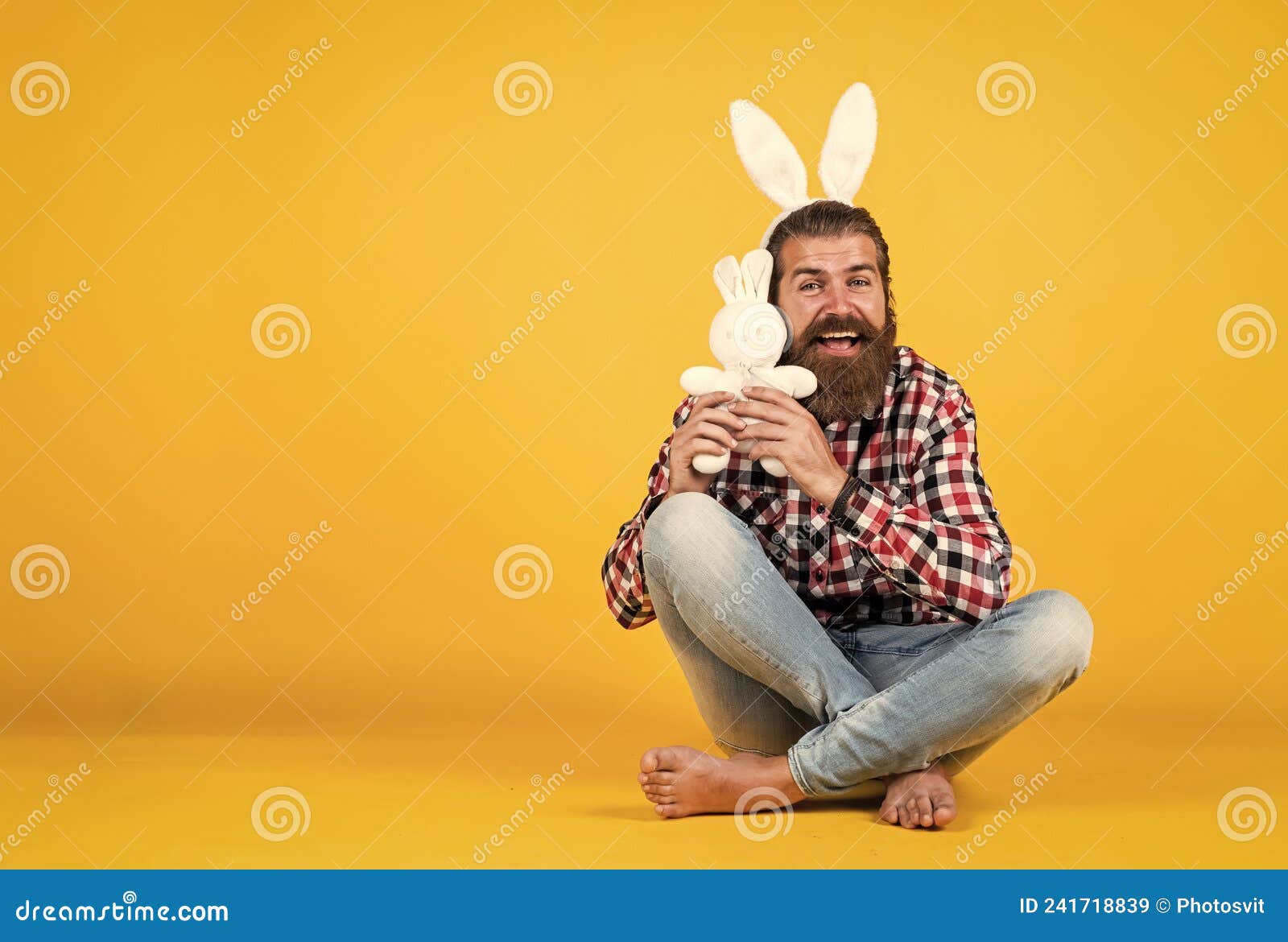 caucasian mature hipster in buny ears with trendy hairstyle in checkered shirt celebrate easter, copy space, easter joy