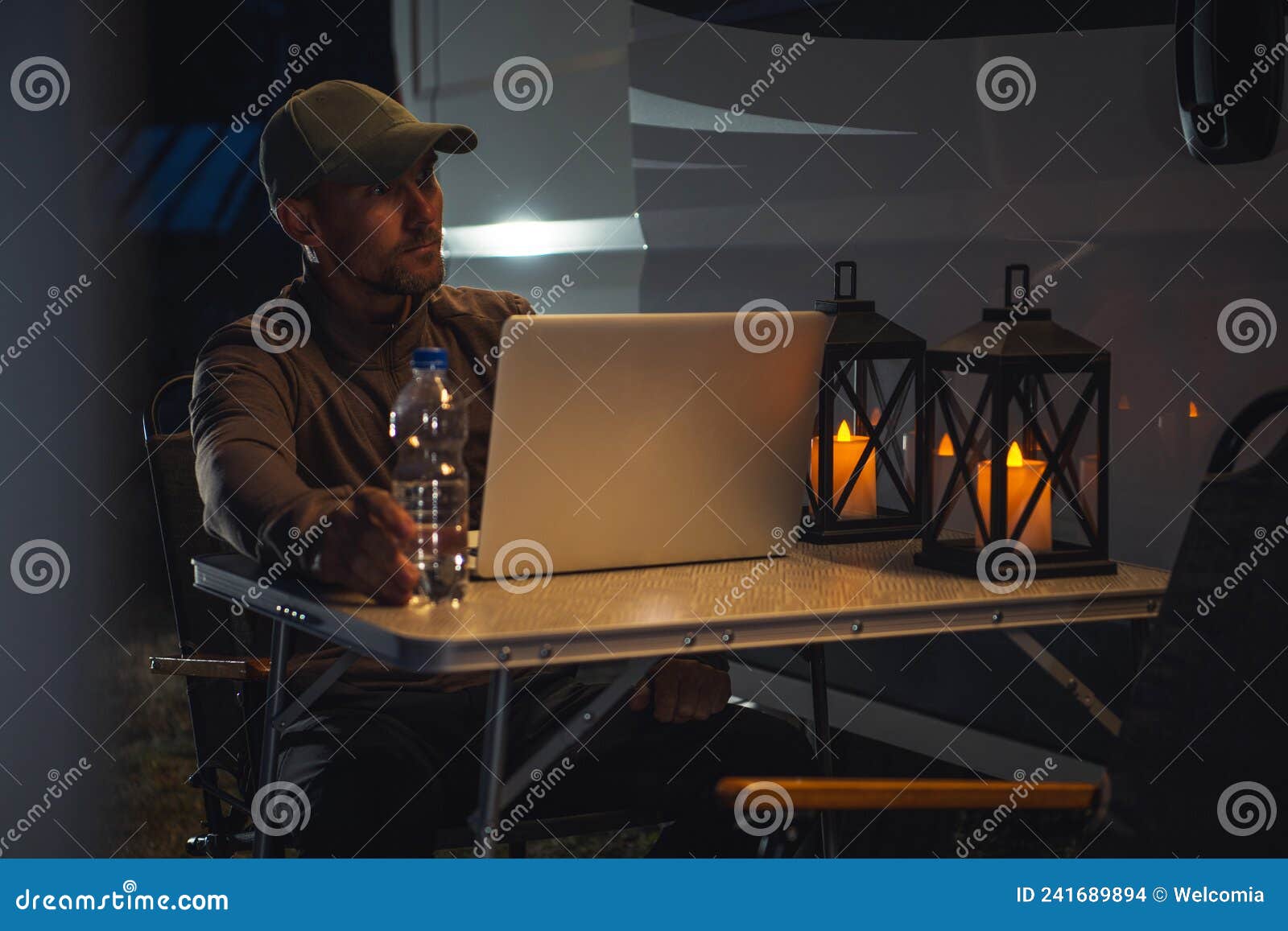 caucasian men working remotely next to his rv motorhome