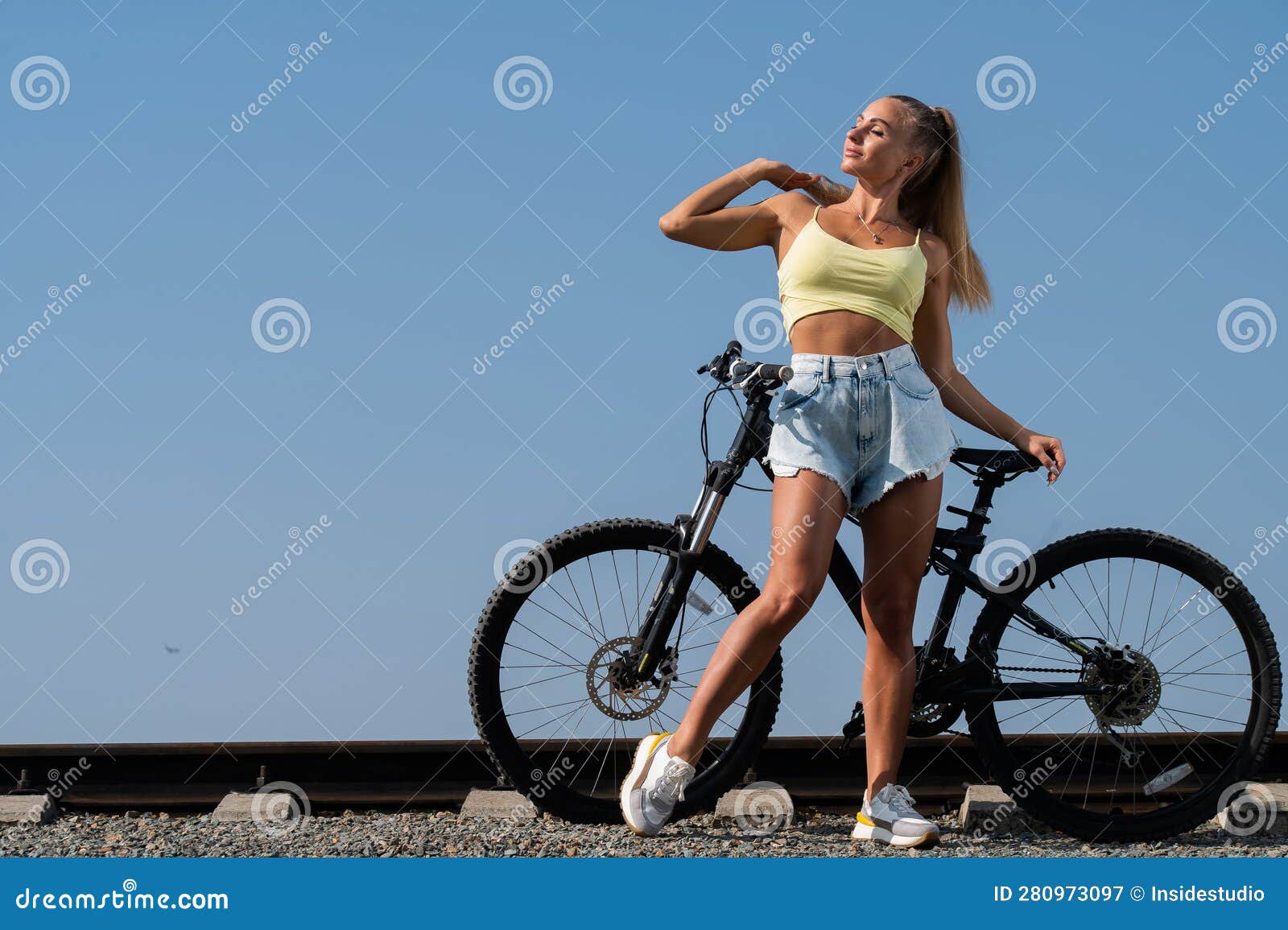Caucasian Woman in Denim Shorts and Top Posing with a Bike on a Hot ...