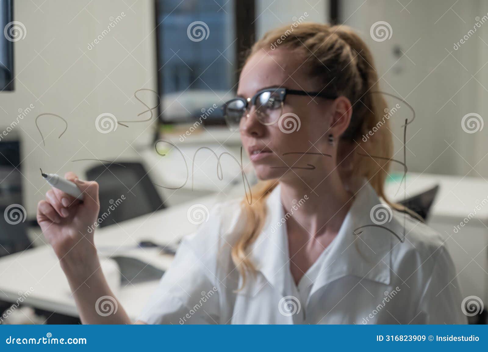 a caucasian woman in a medical gown thinks and finalizes formulas on a transparent wall.