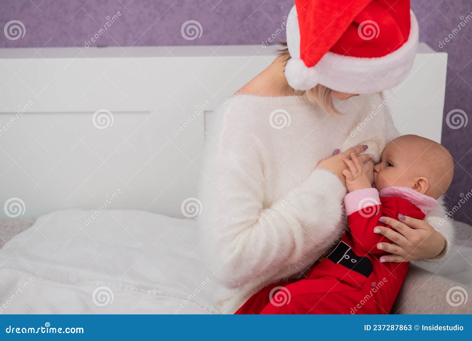 Caucasian Woman Breastfeeding Her Son In Santa Claus Costume Stock