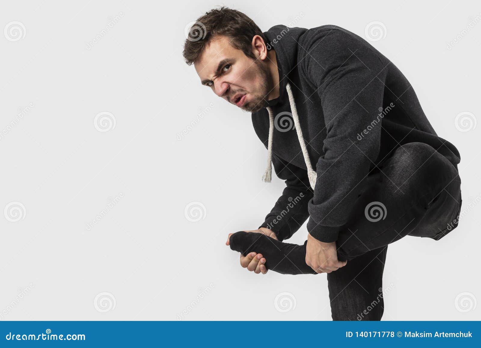 The Guy with Dirty Socks in His Hands on a White Background. Stock