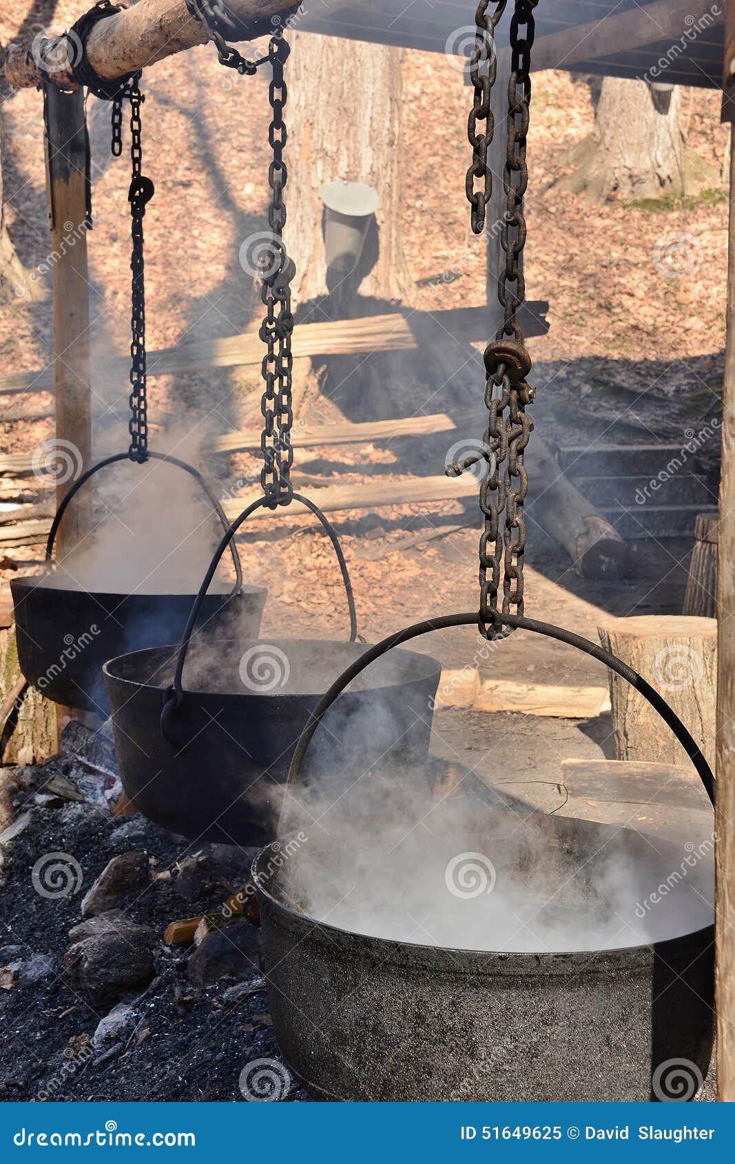 cauldrons steaming over an open fire concentrating maple syrup slowly