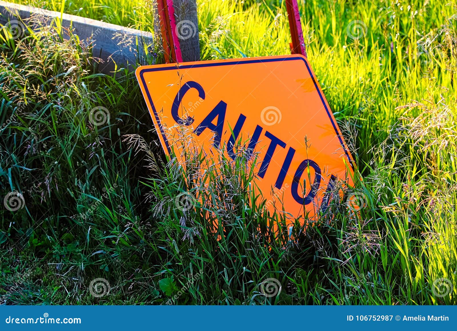 A Caution Construction Sign Laying in the Grass Stock Image Image of