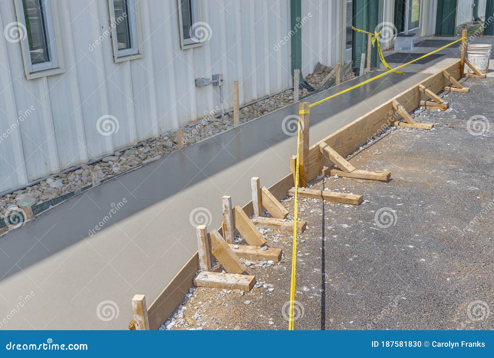 caution tape guards a freshly poured concrete sidewalk