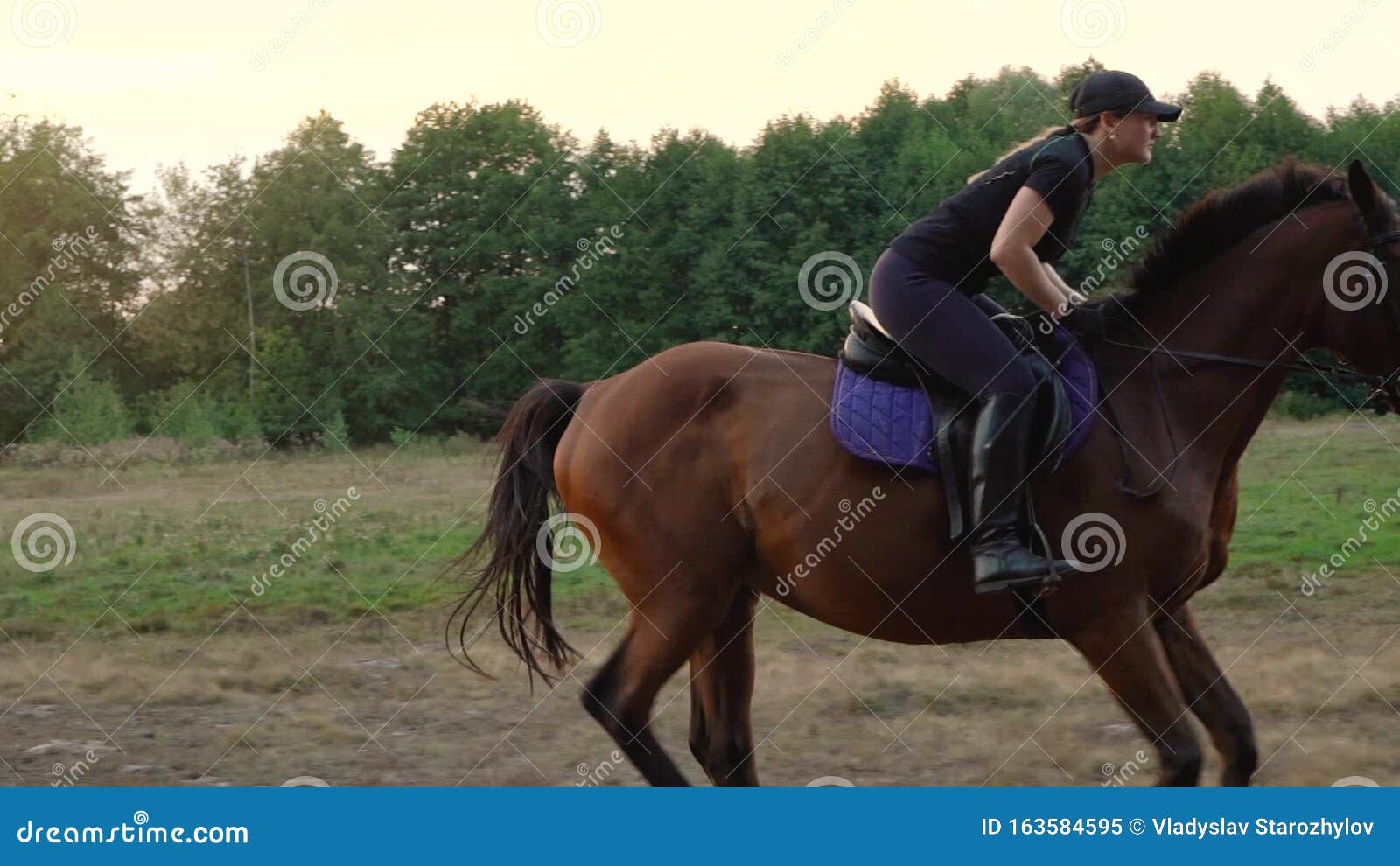 Há uma mulher andando a cavalo pulando sobre uma cerca de madeira