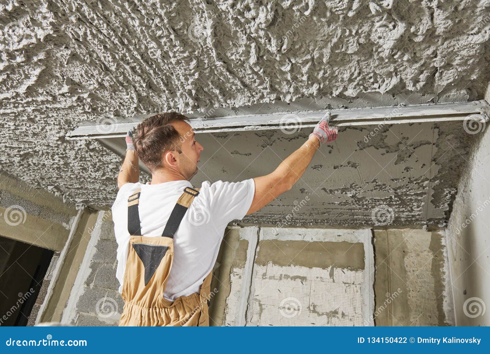 Plasterer Smoothing Plaster Mortar On Ceiling With Screeder Stock