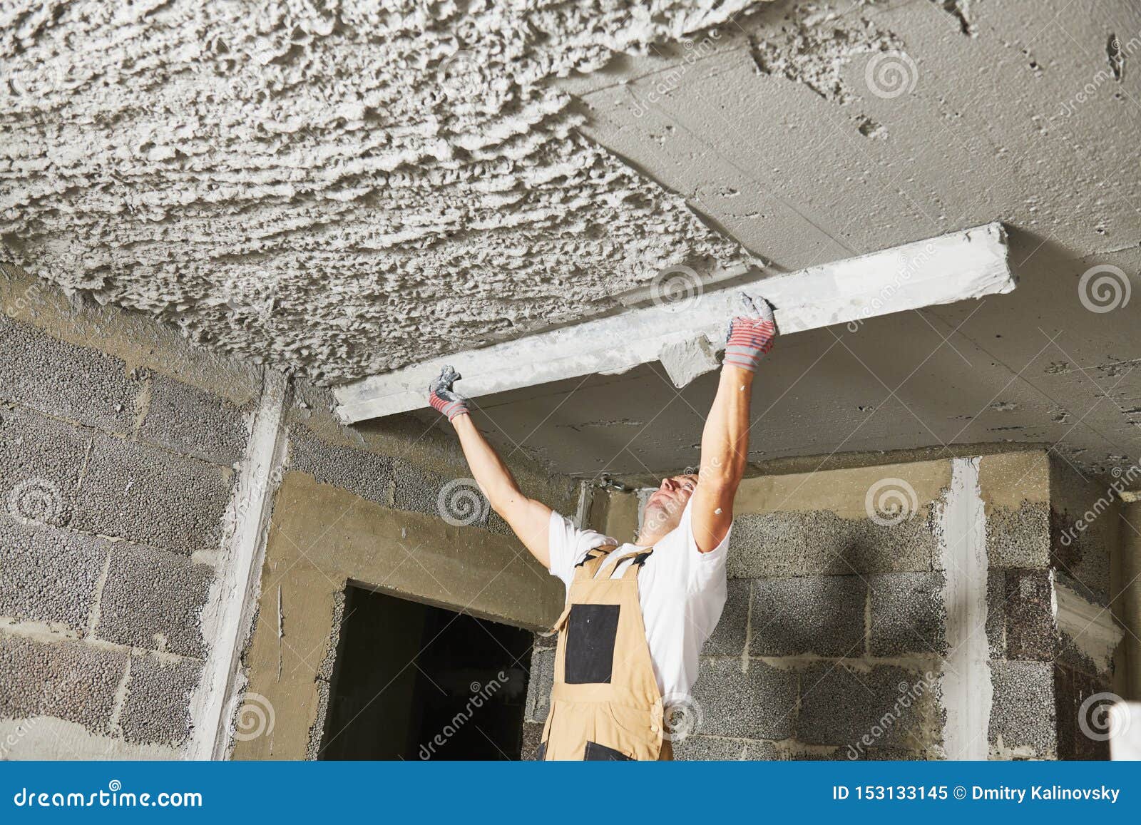 plasterer smoothing plaster mortar on ceiling with screeder