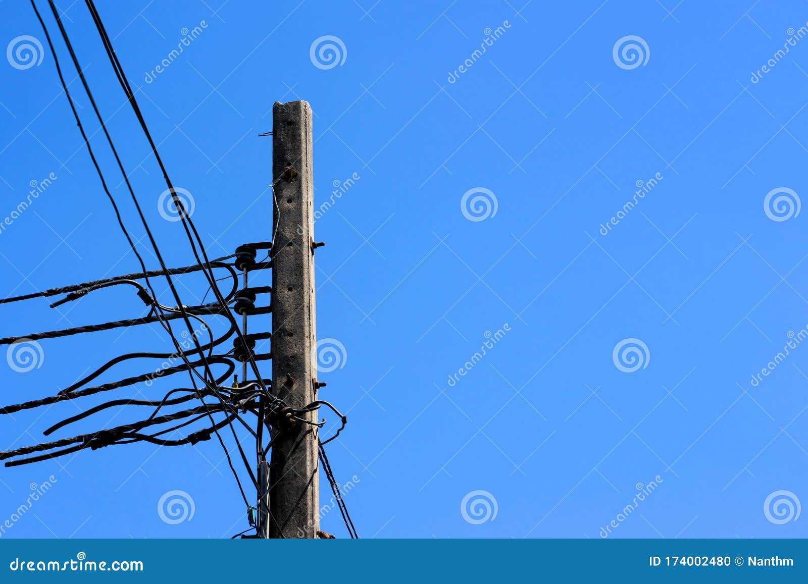 Cement Electricity Pole with Wires on Blue Sky with Text Space Stock