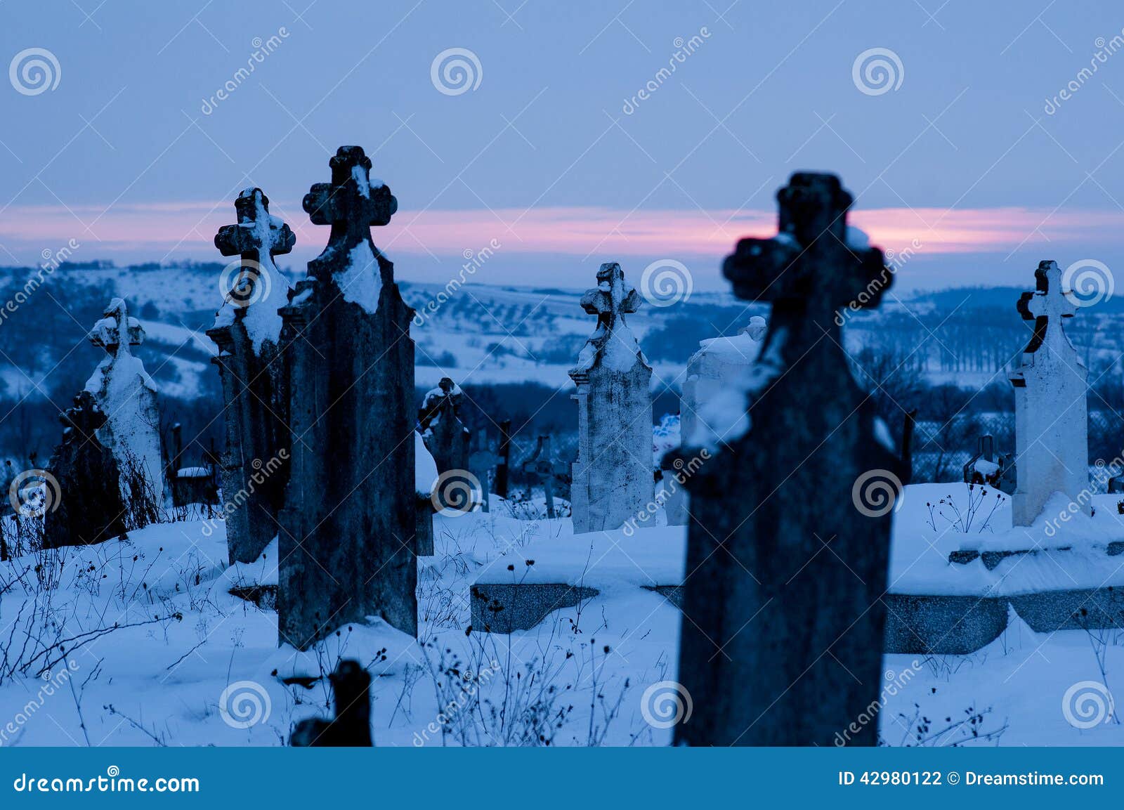cemetery, graveyard with tombstones winter at dawn