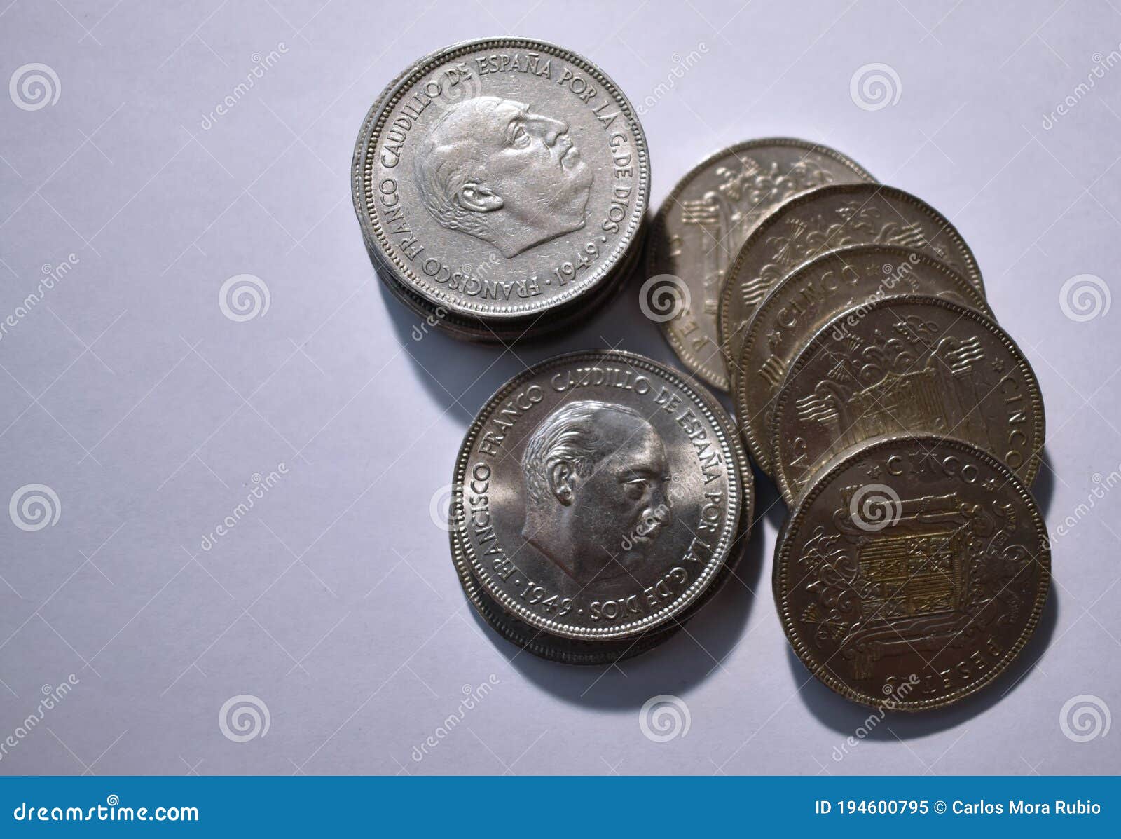 cenital view of a pile of five peseta coins from 1949 and white background