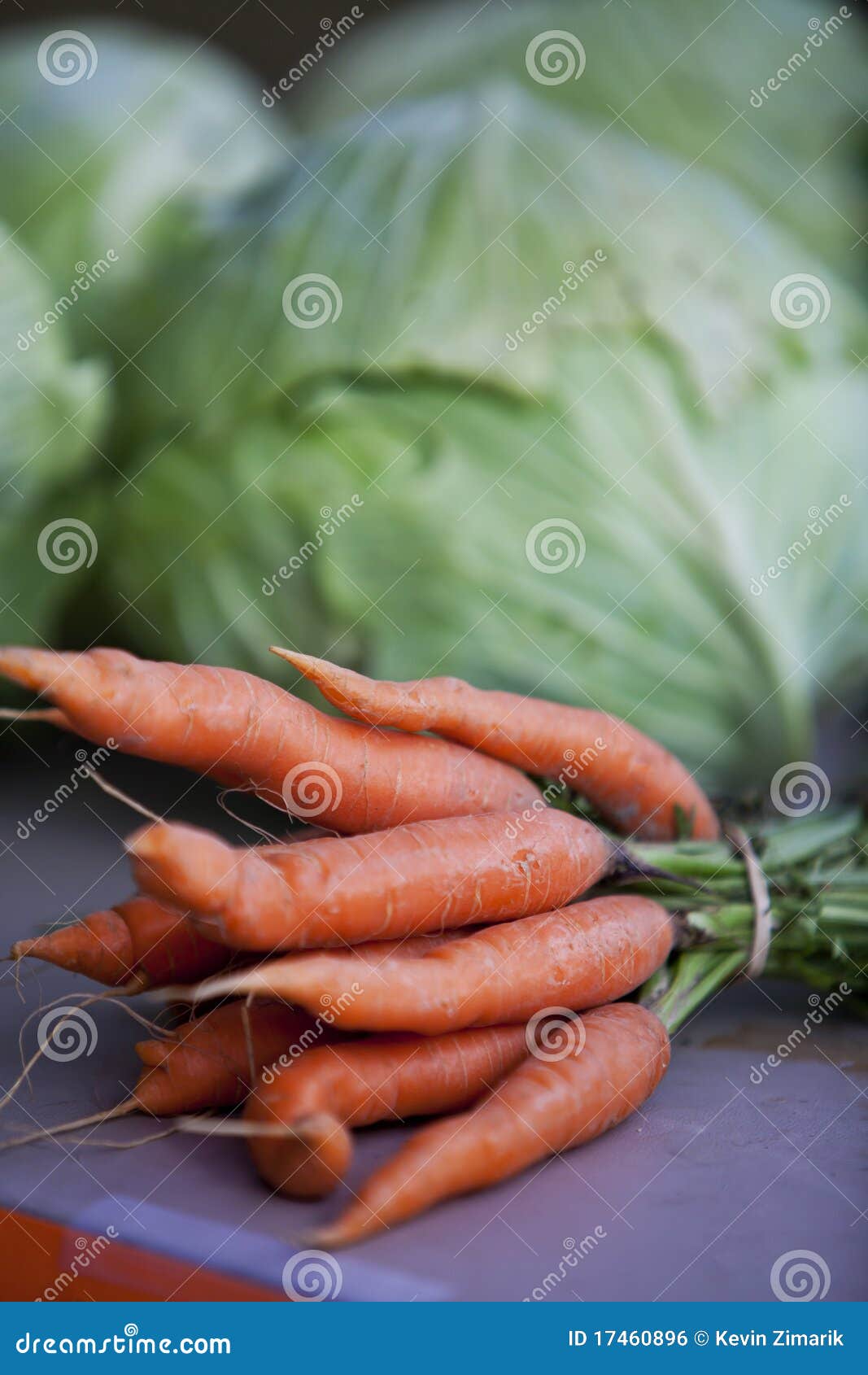 Uma foto do close up de um pacote de cenouras e de vegetais em uma tabela em um mercado dos fazendeiros.