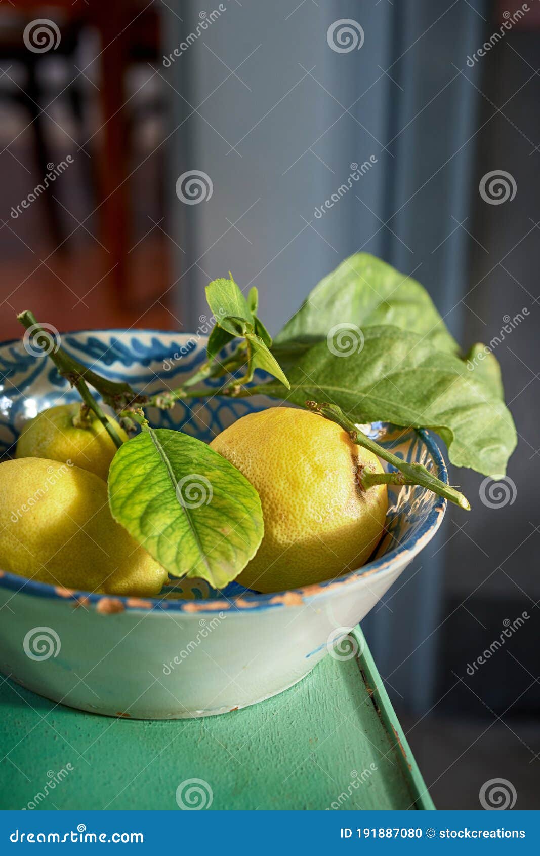 ceramic bowl of fresh yellow lemons with leaves