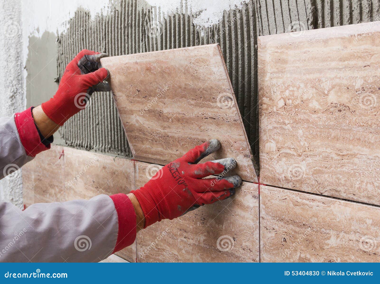 Ceramic Tiles. Tiler Placing Ceramic Wall Tile in Position Over Stock