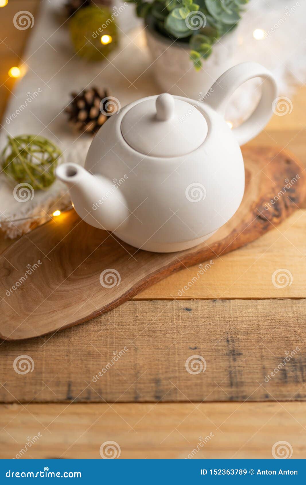 Ceramic White Teapot with Accessories on a Wooden Table, Vertical Frame