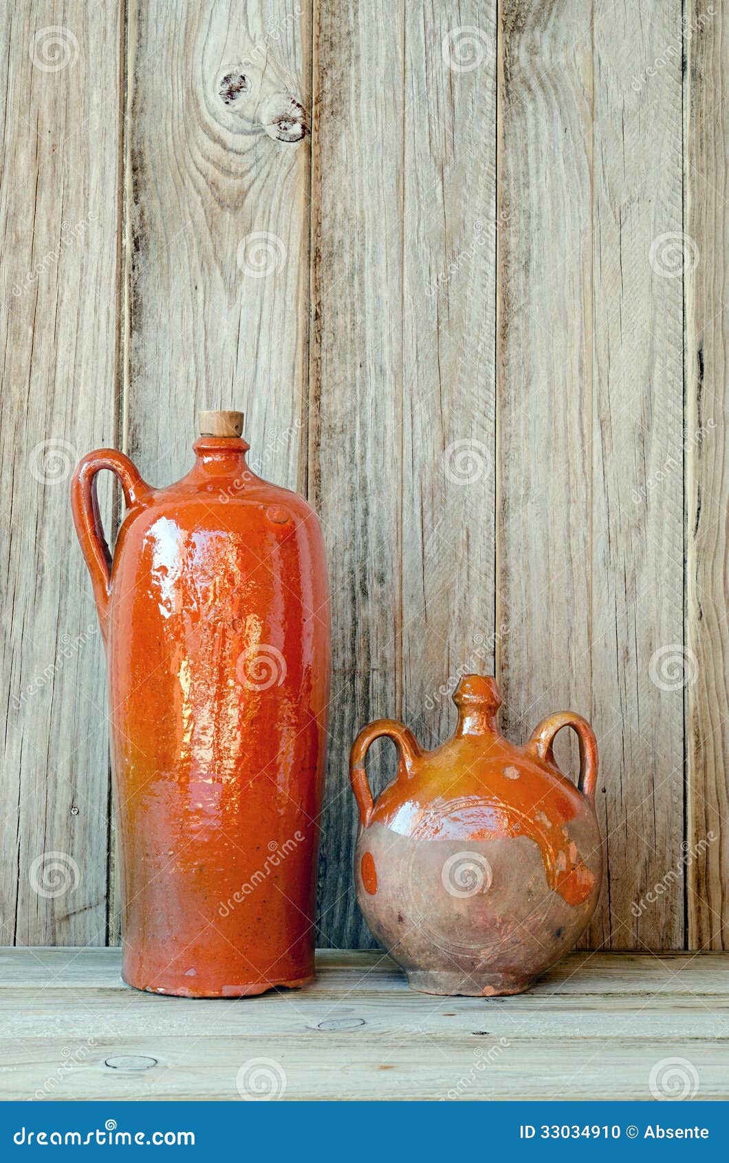 Ceramische Flessen. Twee oude aardewerkflessen op een houten plankachtergrond