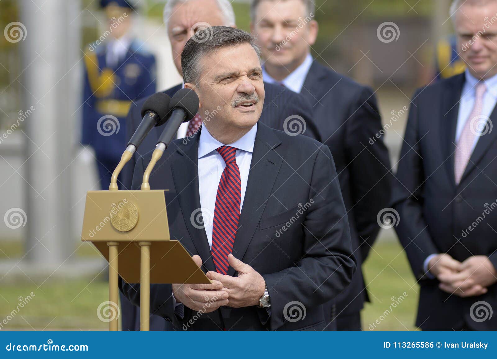 Cerimônia de solene de içar as bandeiras antes do campeonato do hóquei do mundo. MINSK, BIELORRÚSSIA - 8 DE MAIO: Rene Fasel - conversa do presidente de IIHF durante a cerimônia de solene de içar as bandeiras dos países que participam no campeonato do hóquei do mundo o 8 de maio de 2014 em Minsk, Bielorrússia