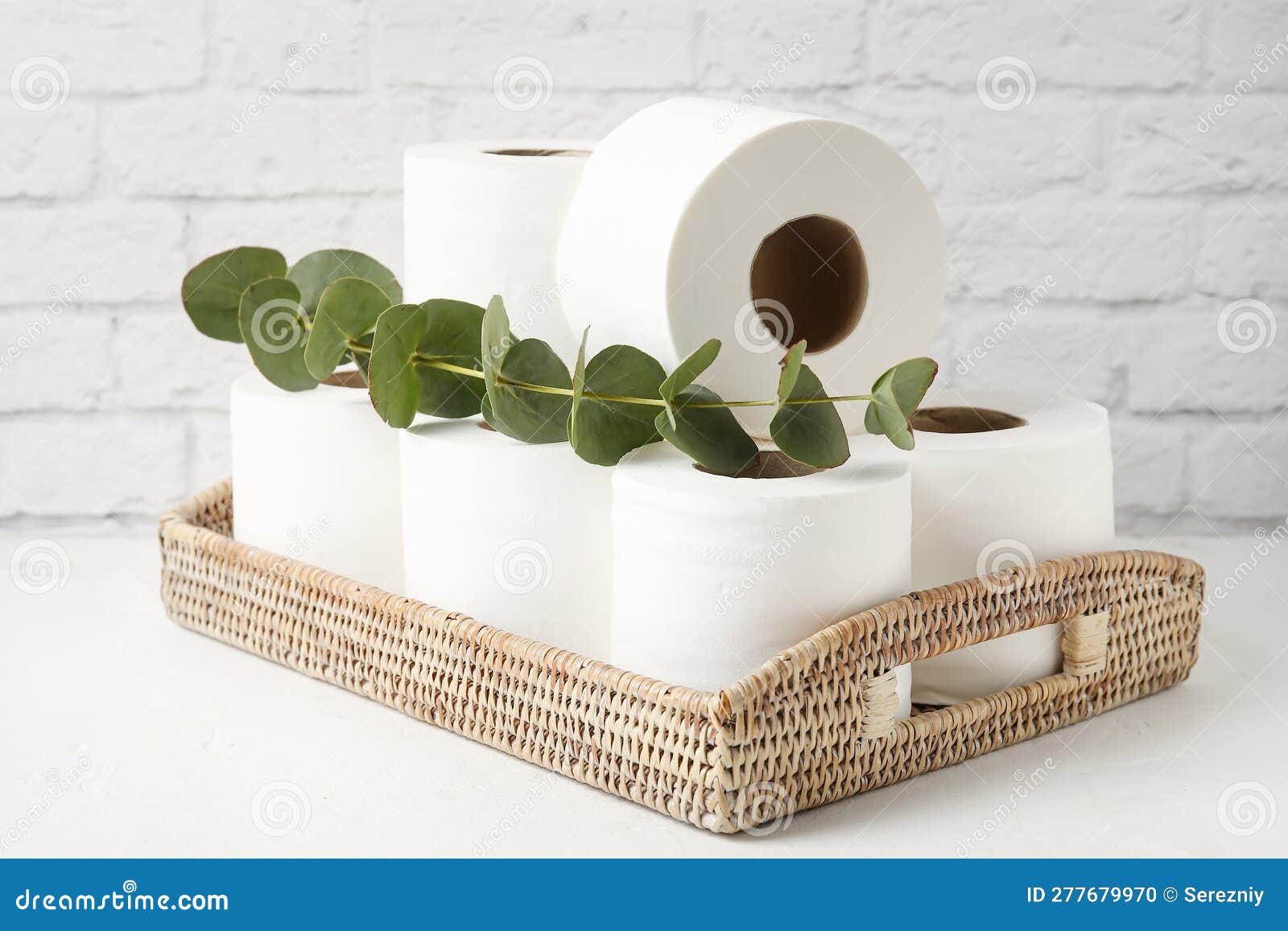 Cesta Con Rollos De Papel Higiénico Y Eucalipto Sobre La Mesa Cerca De La  Pared De Ladrillo Foto de archivo - Imagen de sanitario, cesta: 277679970