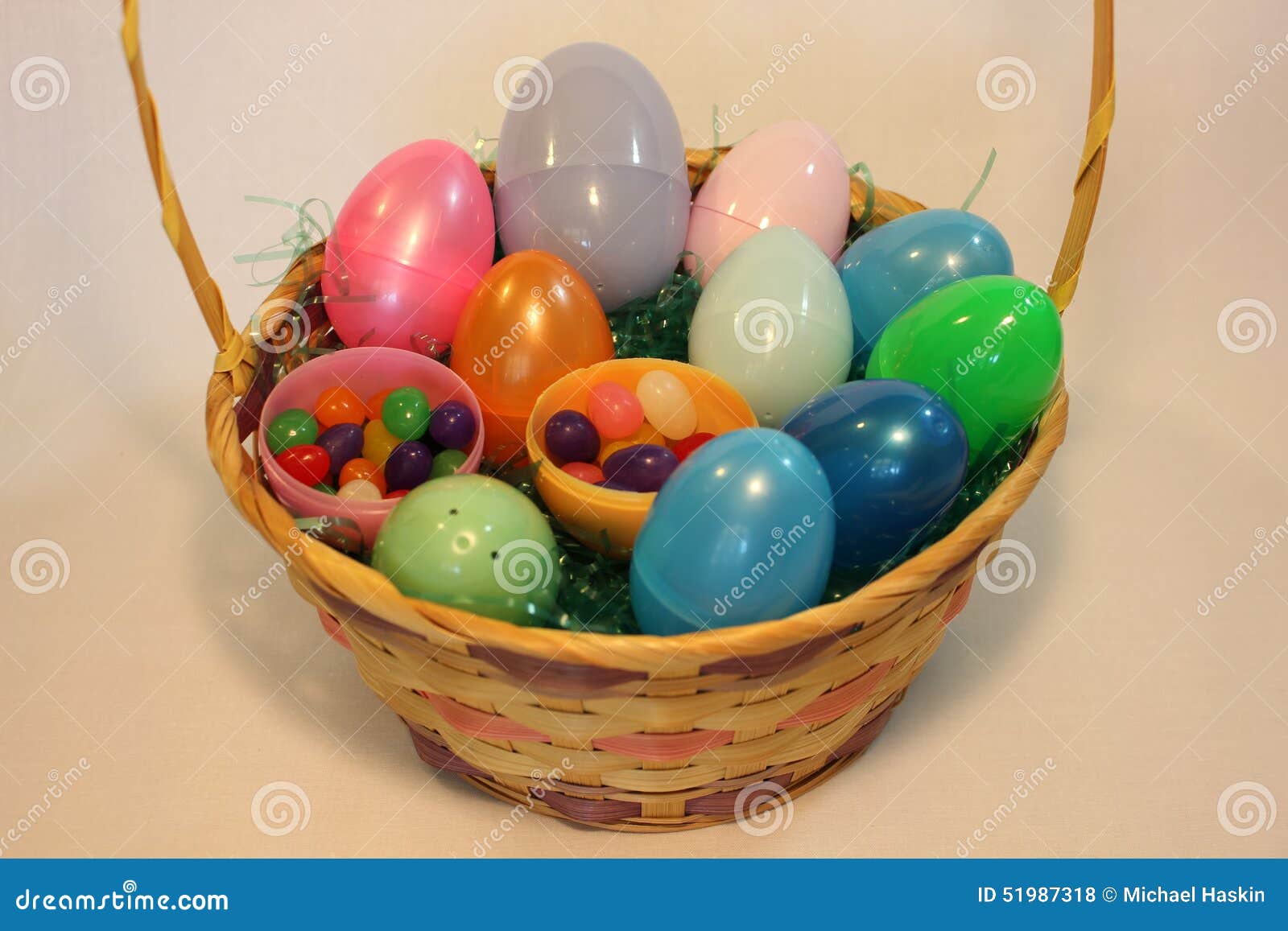 Cesta da Páscoa completamente de ovos plásticos coloridos. Uma cesta com muitos ovos enchidos doces
