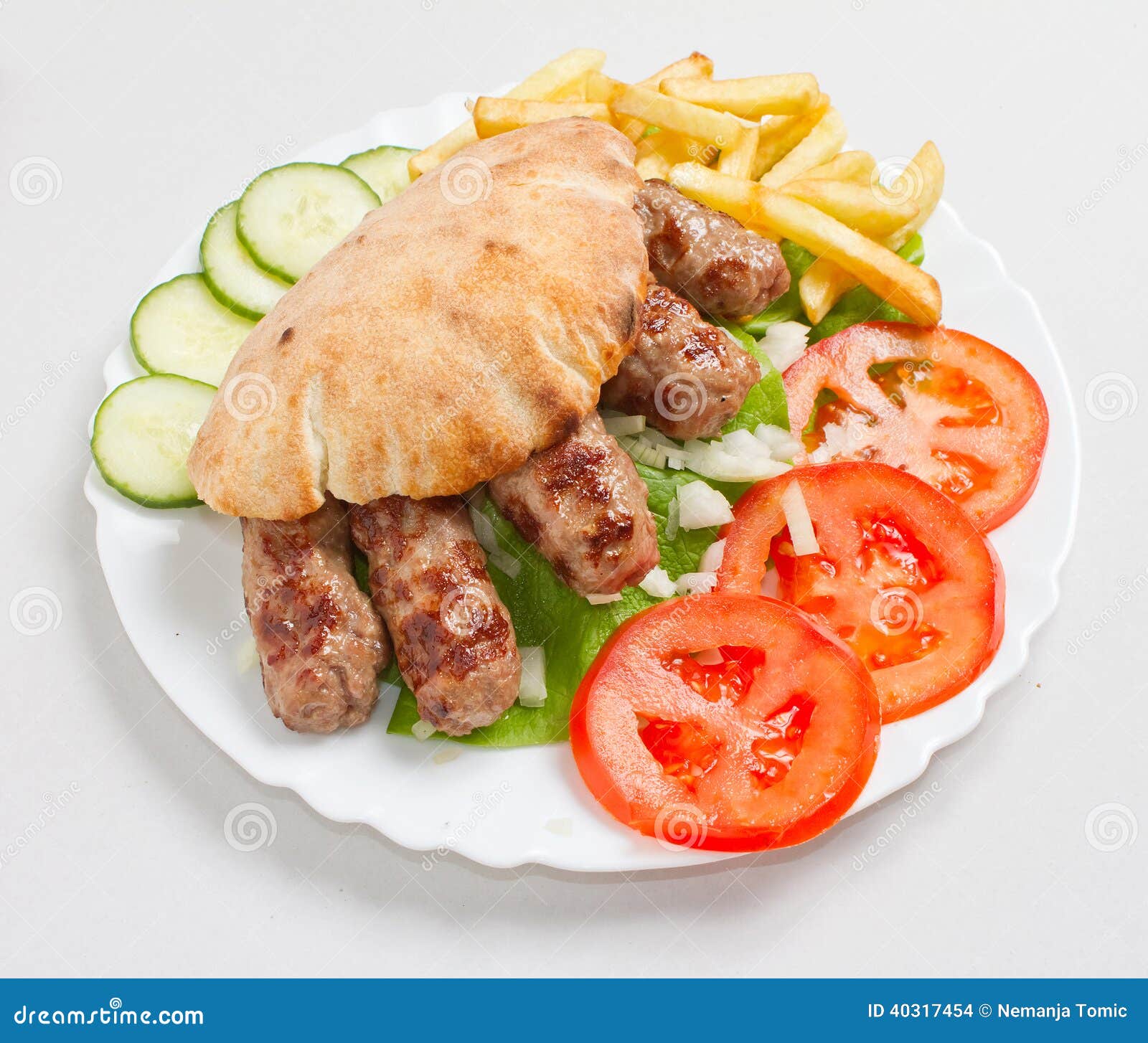 Freshly grilled kebab cevapi with tomato, onion, cucumber and homemade bun