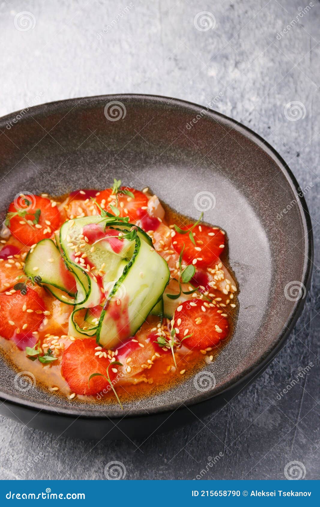 ceviche with srawberry and cucumber closeup on light concrete table backdrop