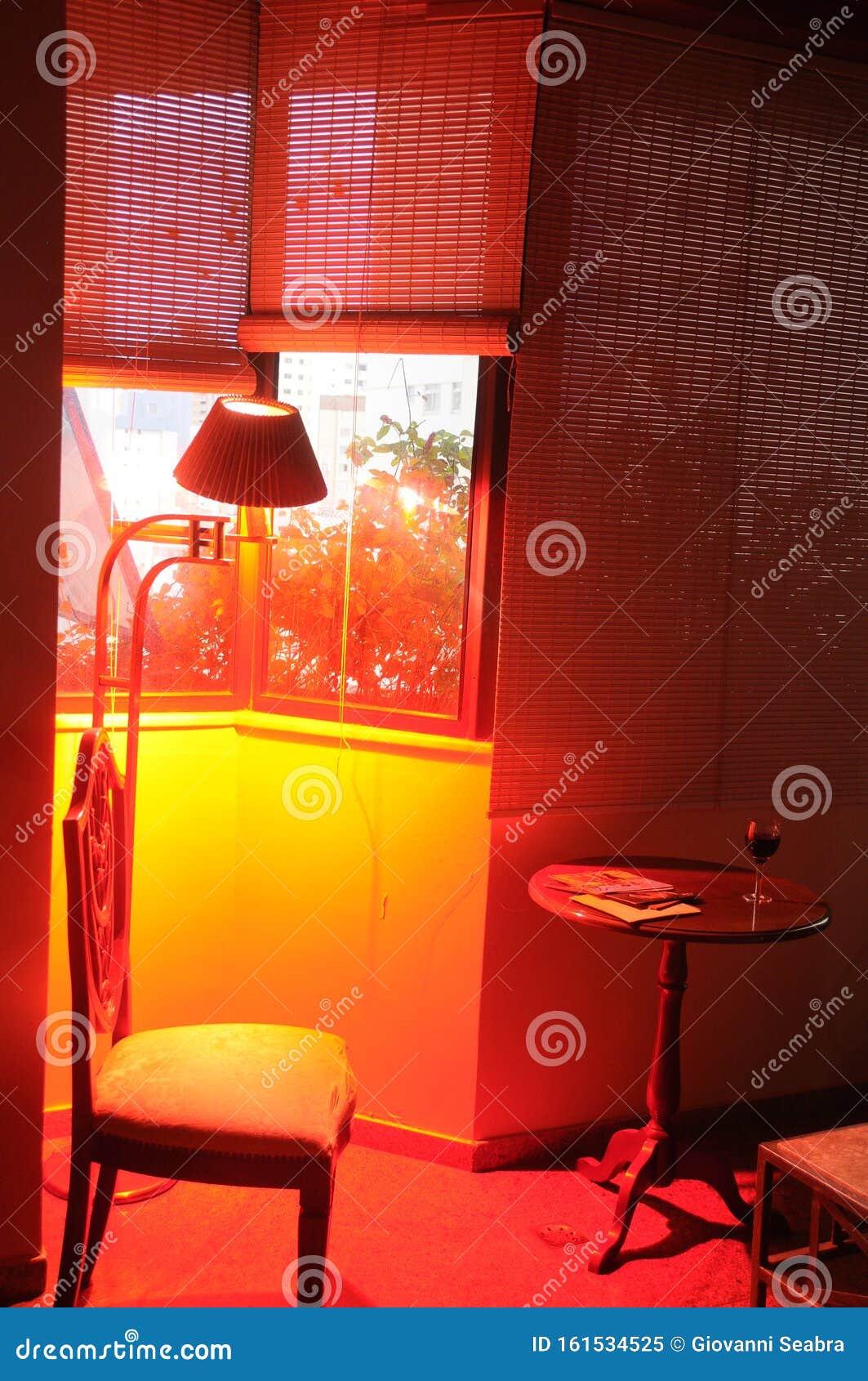 CHAIR UNDER WINDOW with RED LIGHT COMING from BACKGROUND Stock Image