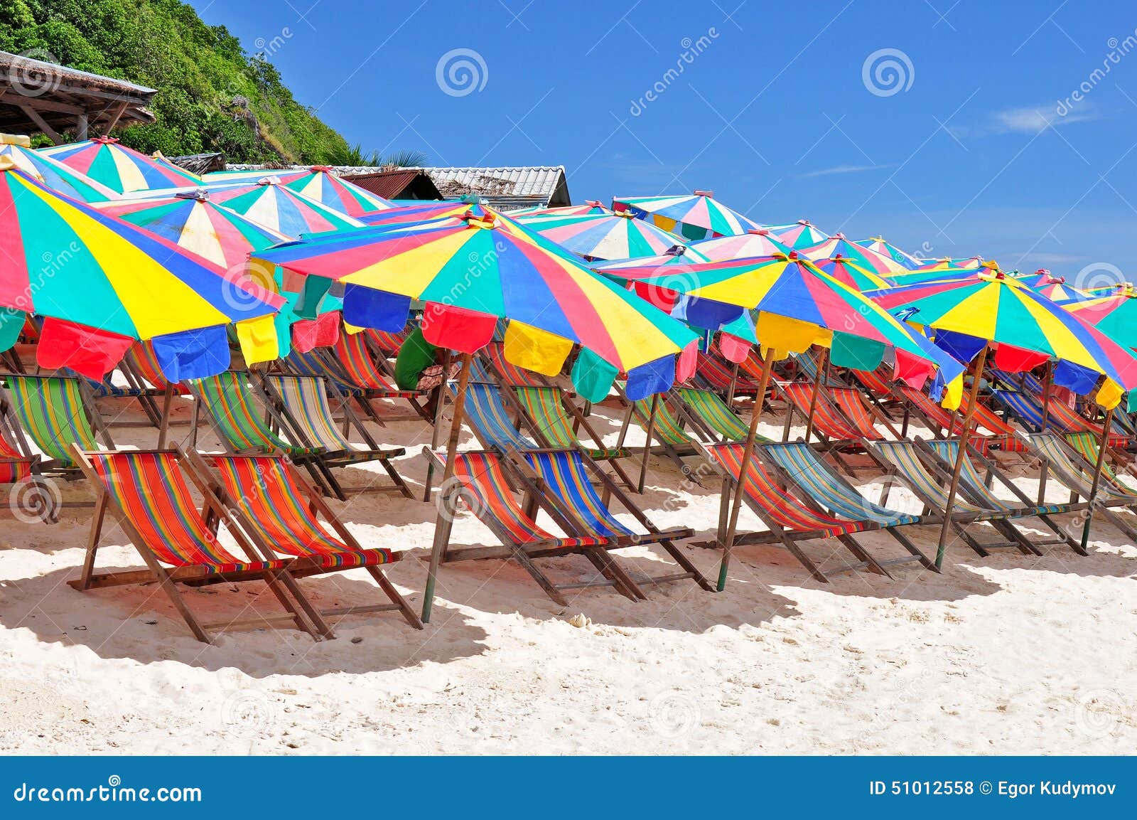 Chaiselongues on a beach stock photo. Image of water 51012558