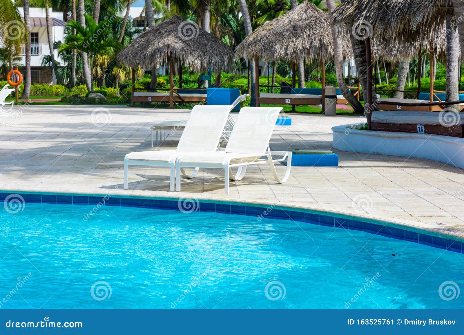 Chaise lounge by the pool stock image. Image of luxury 163525761