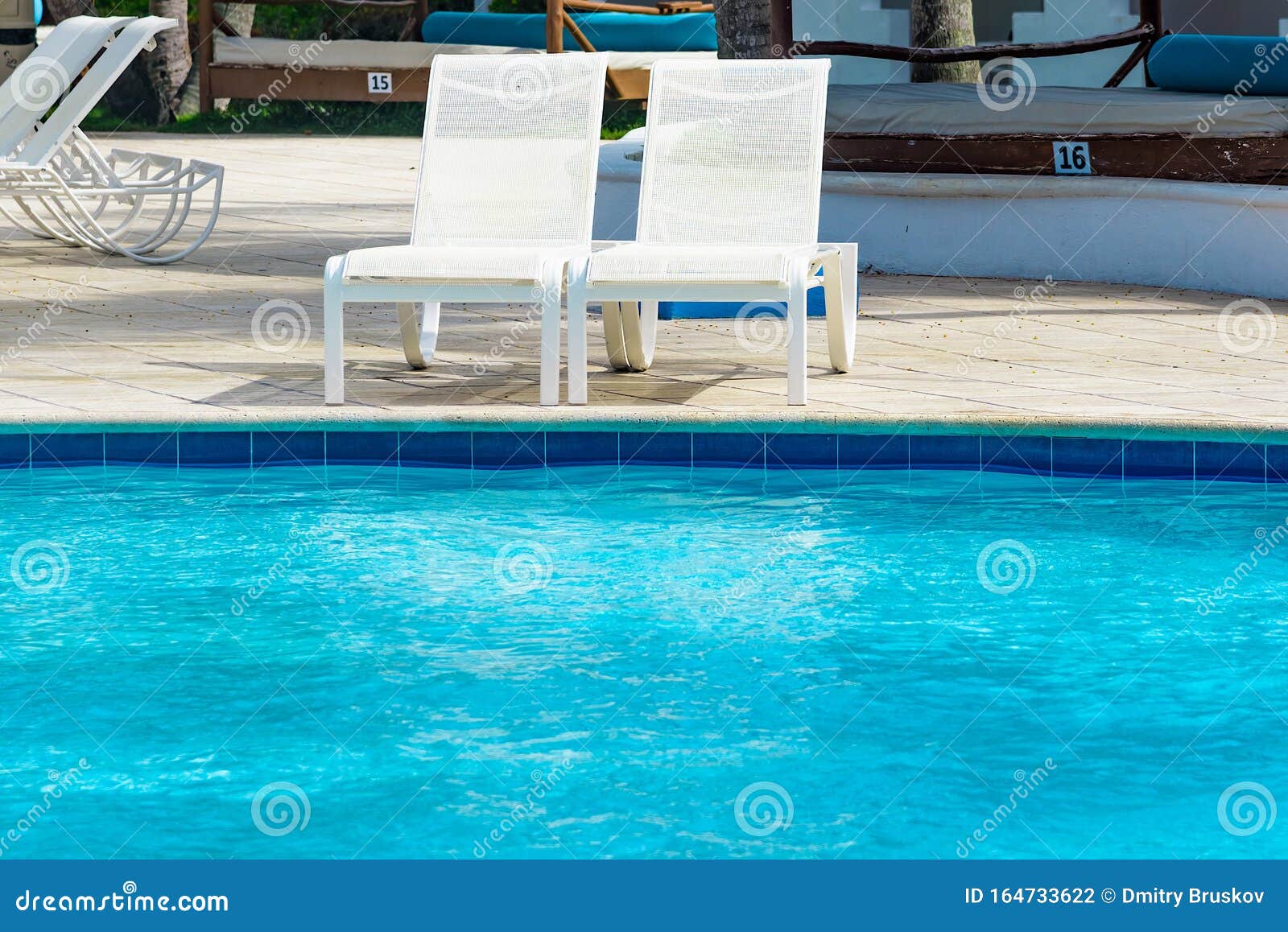 Chaise lounge by the pool stock photo. Image of paradise 164733622