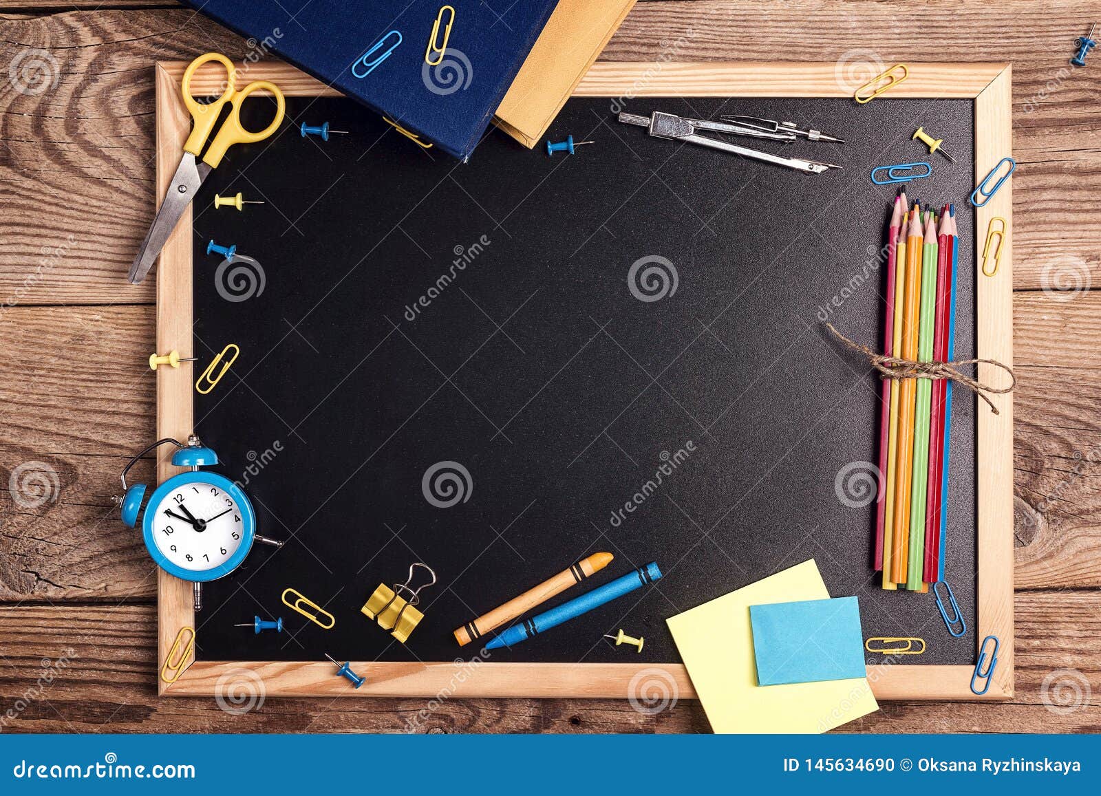 A Chalkboard with School Supplies and Alarm Clock on a Rustic Wooden ...