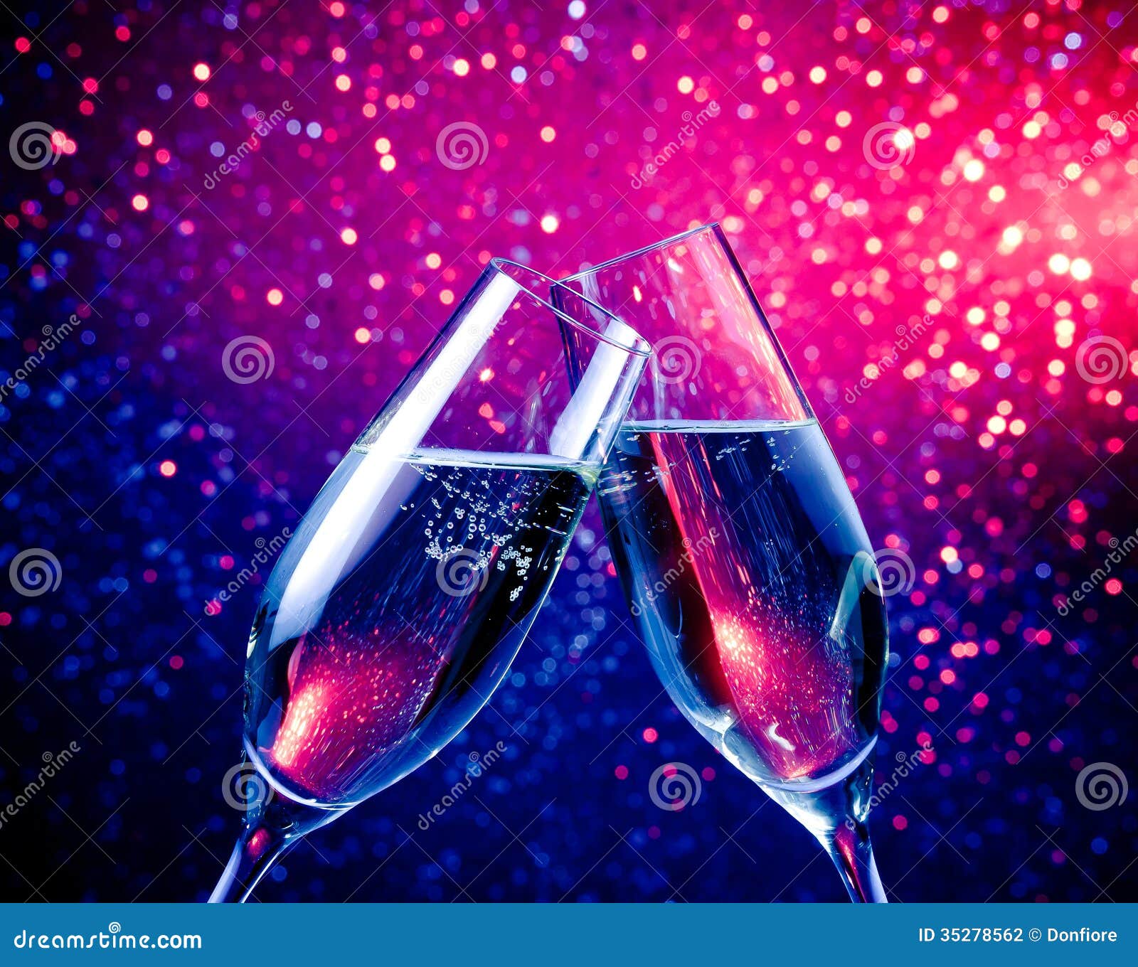 Champagne Flutes with Bubbles on Blue Tint Light Bokeh Background Stock
