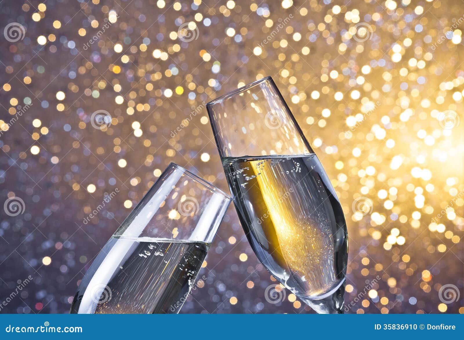 Champagne Flutes with Golden Bubbles on Light Bokeh Background Stock