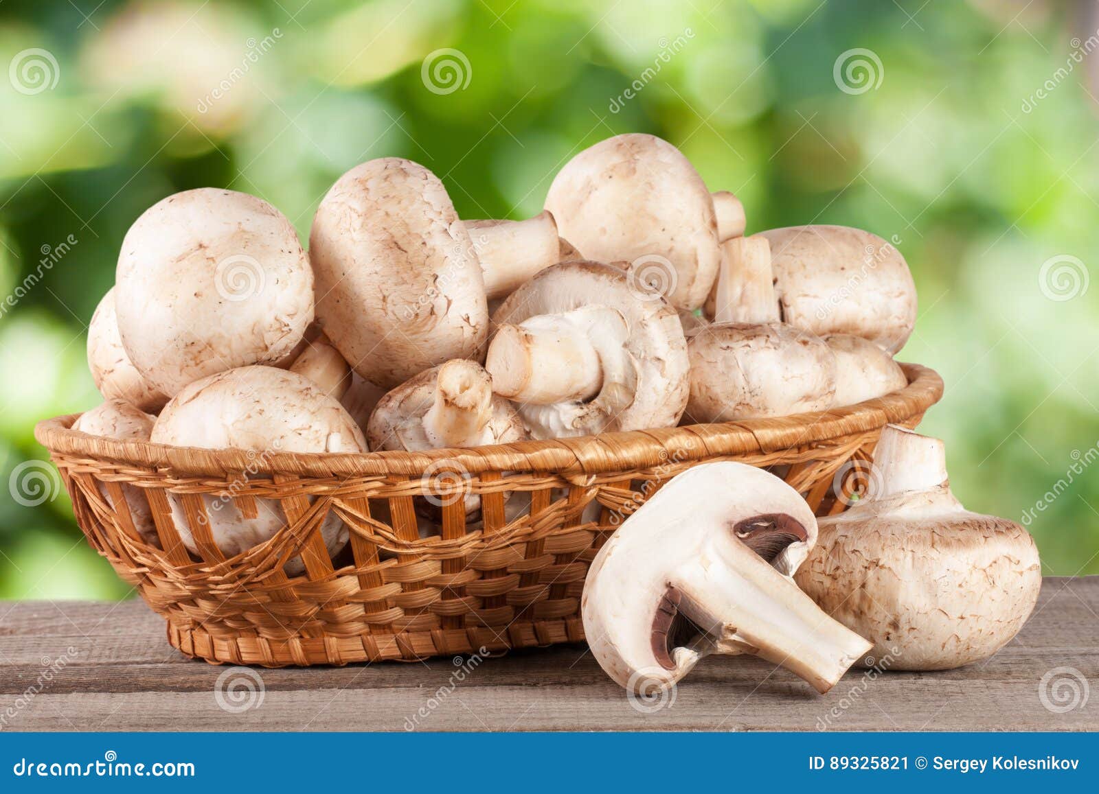 Champignon Mushrooms In A Wicker Basket On Wooden Table With