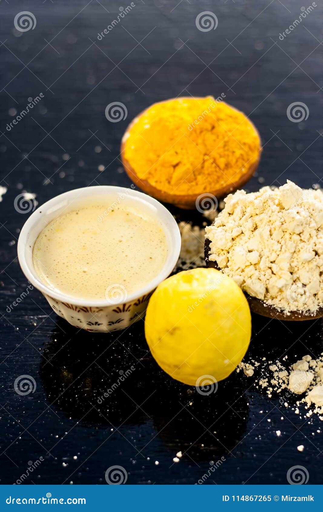 chana,haldi,limbo ka ubtan or ayurvedic face pack of turmeric, lemon, and gram flour on wooden surface for good skin and no acnes