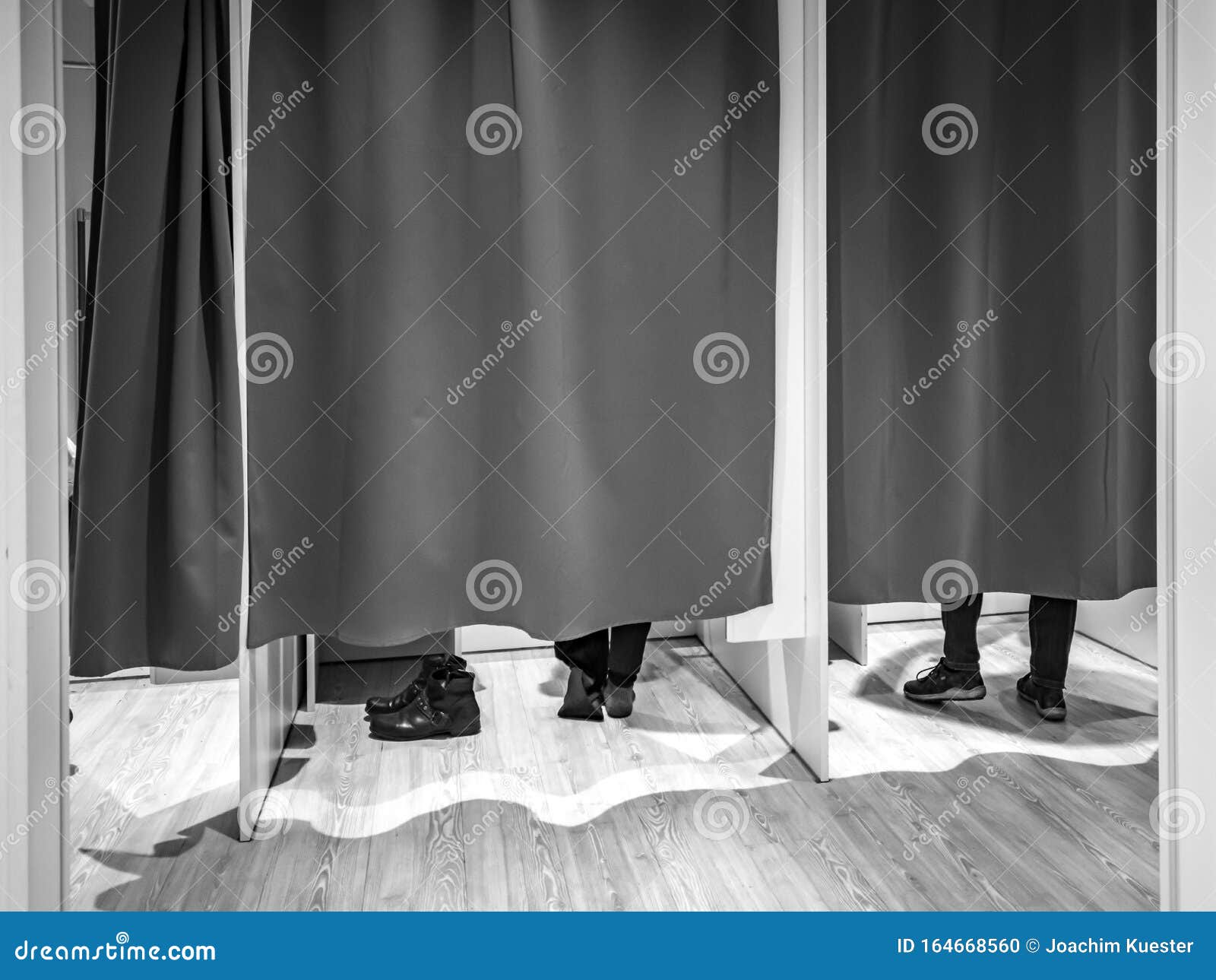 Changing Room with Closed Curtains and Feet of Two Customers Stock