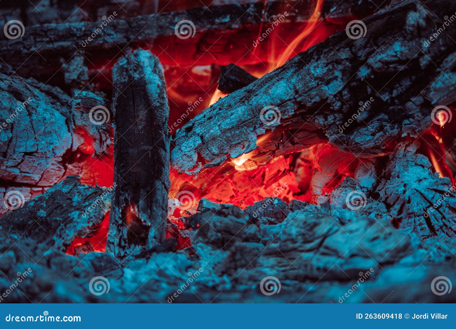 Charcoal and Logs Covered with Ash Burning with Bright Red Fire in