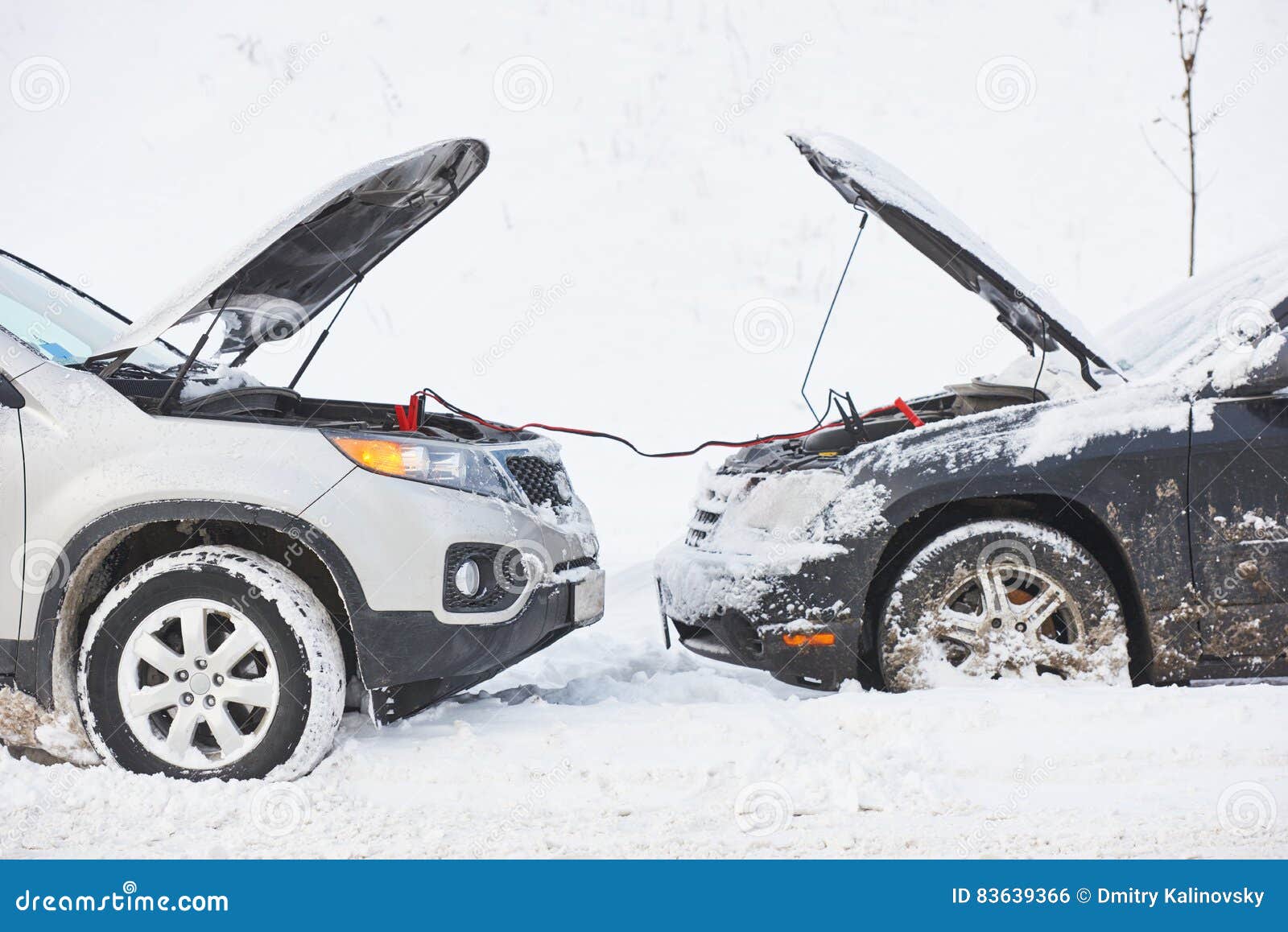 charging automobile discharged battery by booster jumper cables at winter