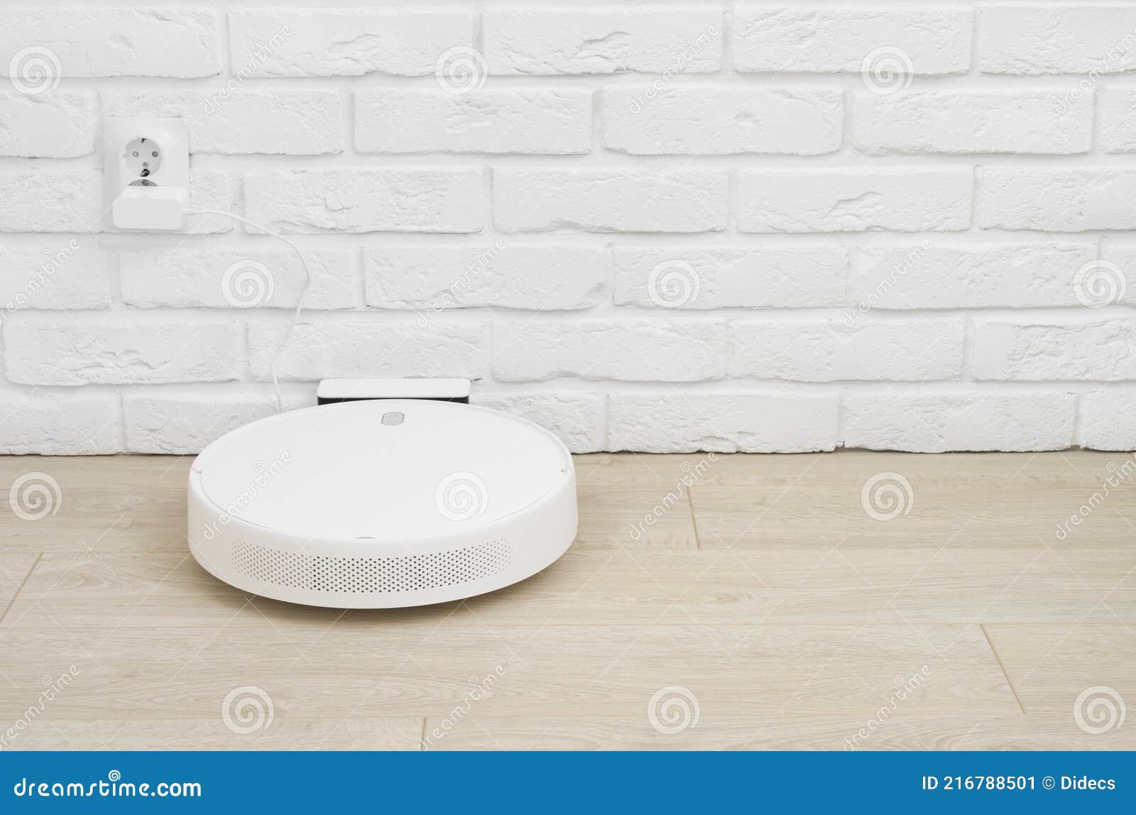 Charging Base with Robot Vacuum Cleaner Plugged into Wall Socket Stock