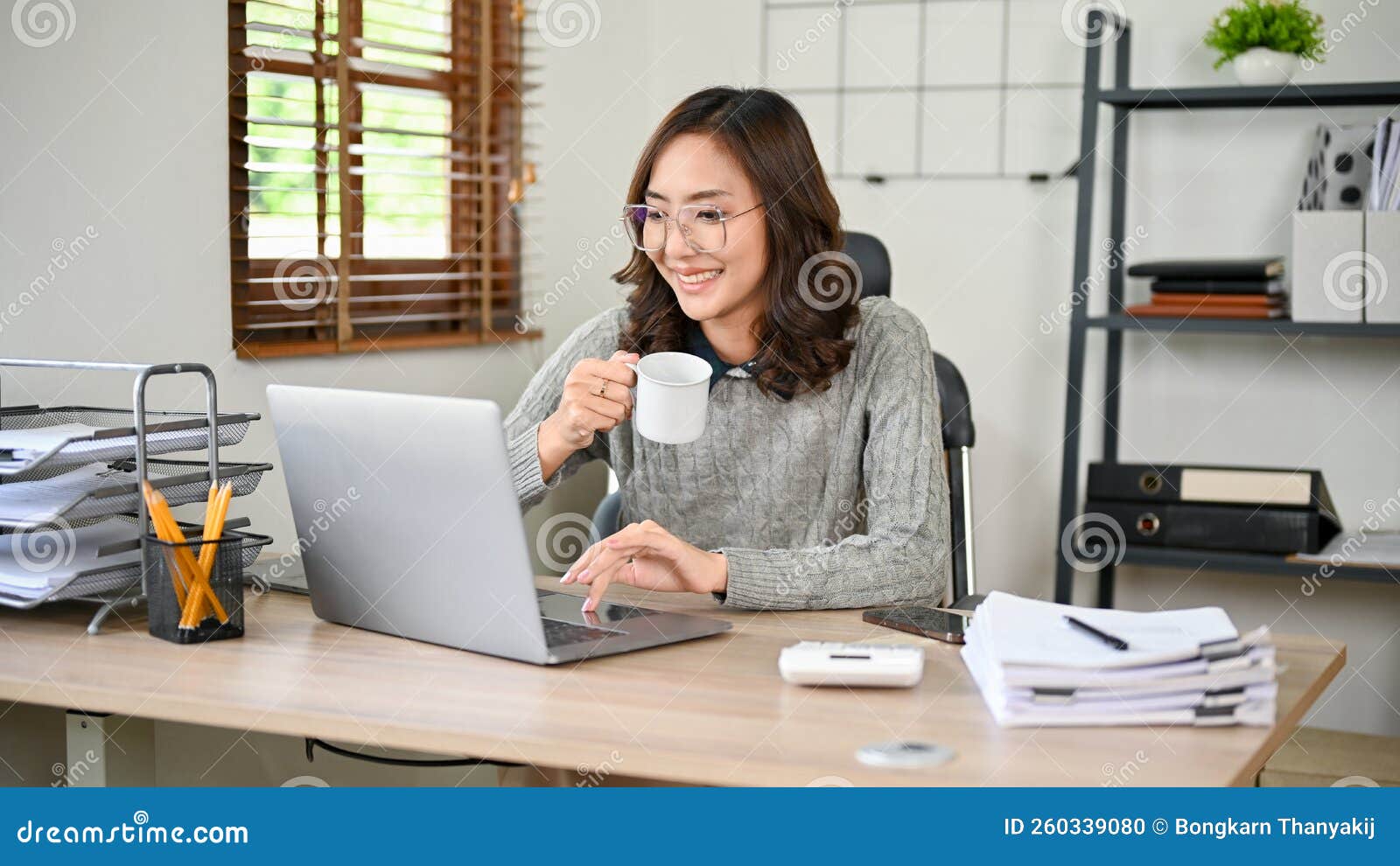 Charming Asian Businesswoman Sipping Coffee while Working on Her Tasks ...