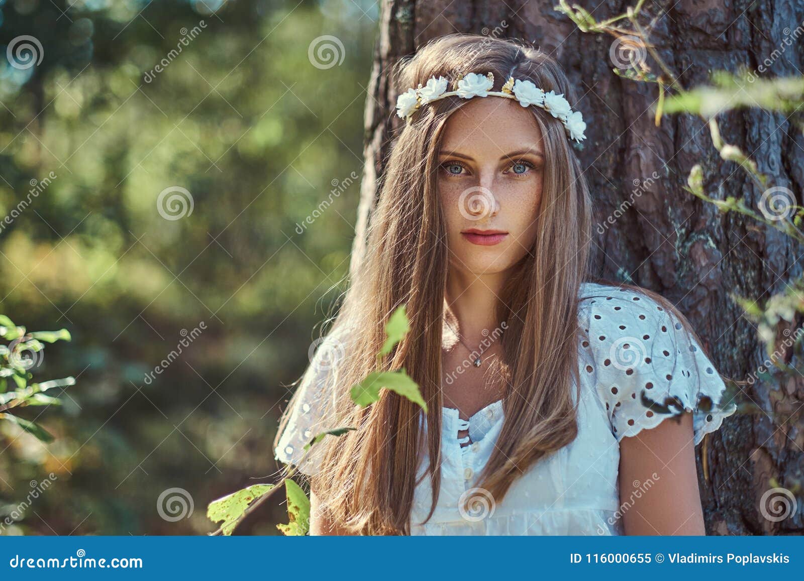 A Beautiful Woman In A White Dress And White Wreath On Head Posing In A Green Autumn Forest