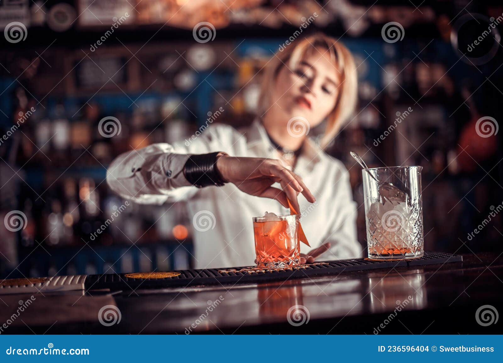 Professional Girl Bartender Decorates Colorful Concoction while ...