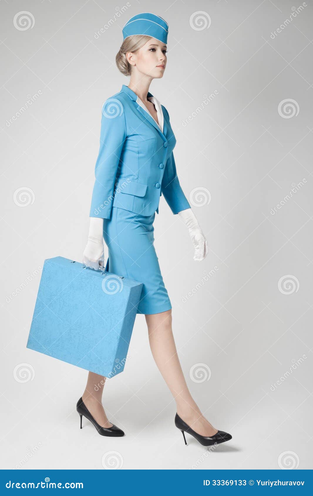 Charming Stewardess in Blue Uniform and Suitcase on Gray Stock Image