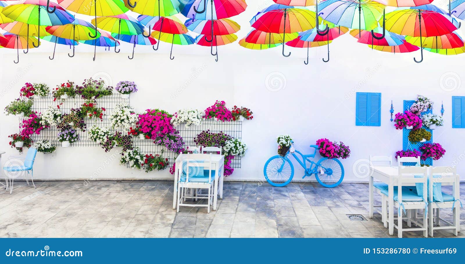 charming street outdoor decoration with old bicycle , flowers and umbrellas. bodrum, turkey