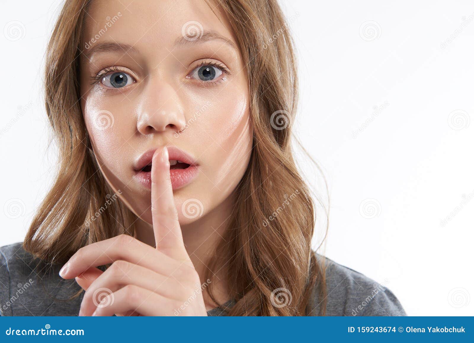 Charming Teen Girl Keeping Finger On Slightly Open Lips Stock Photo