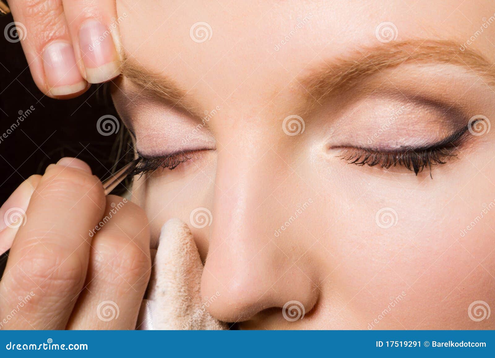 charming young woman applying blusher eyelid