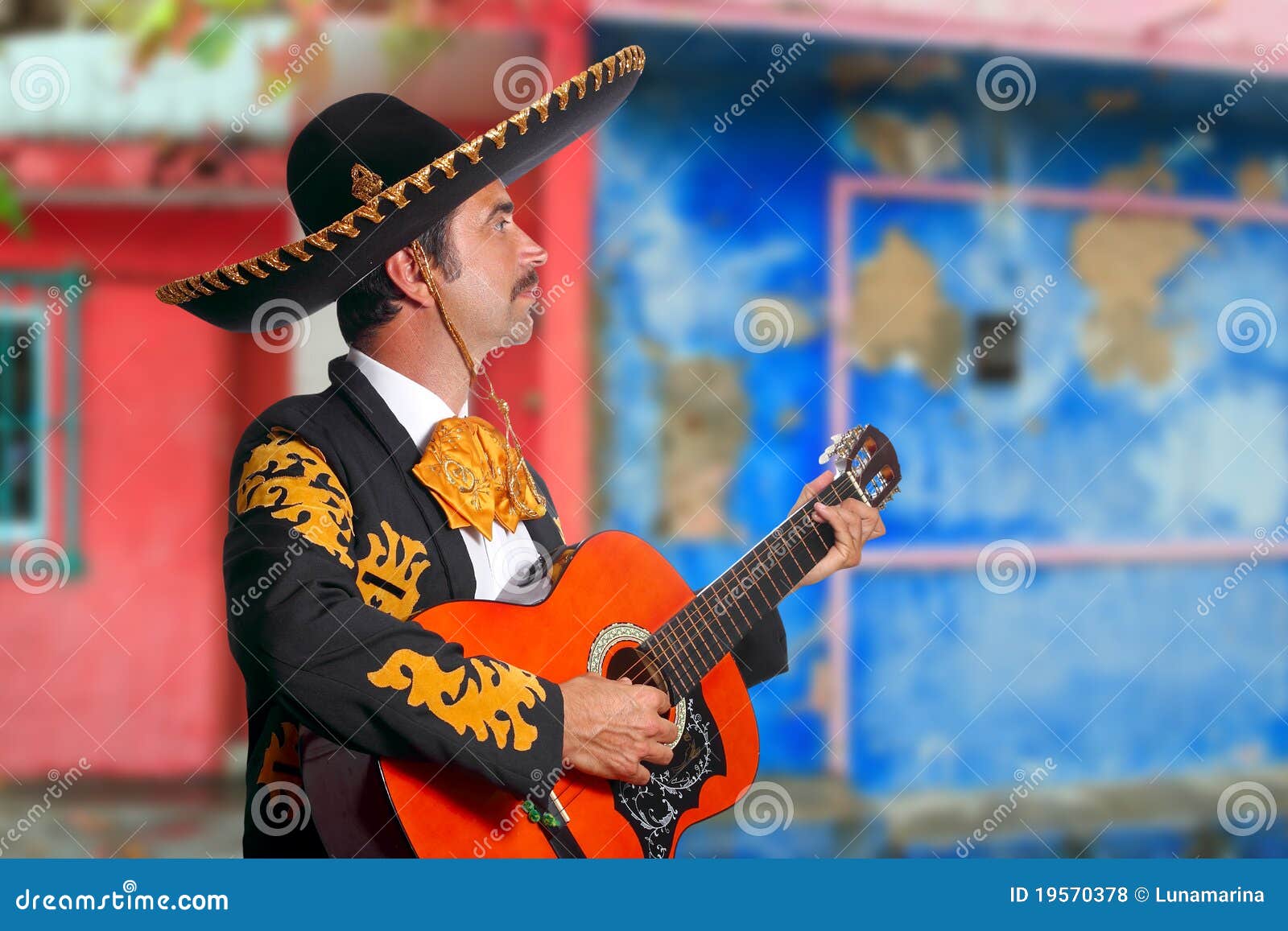 charro mariachi playing guitar mexico houses