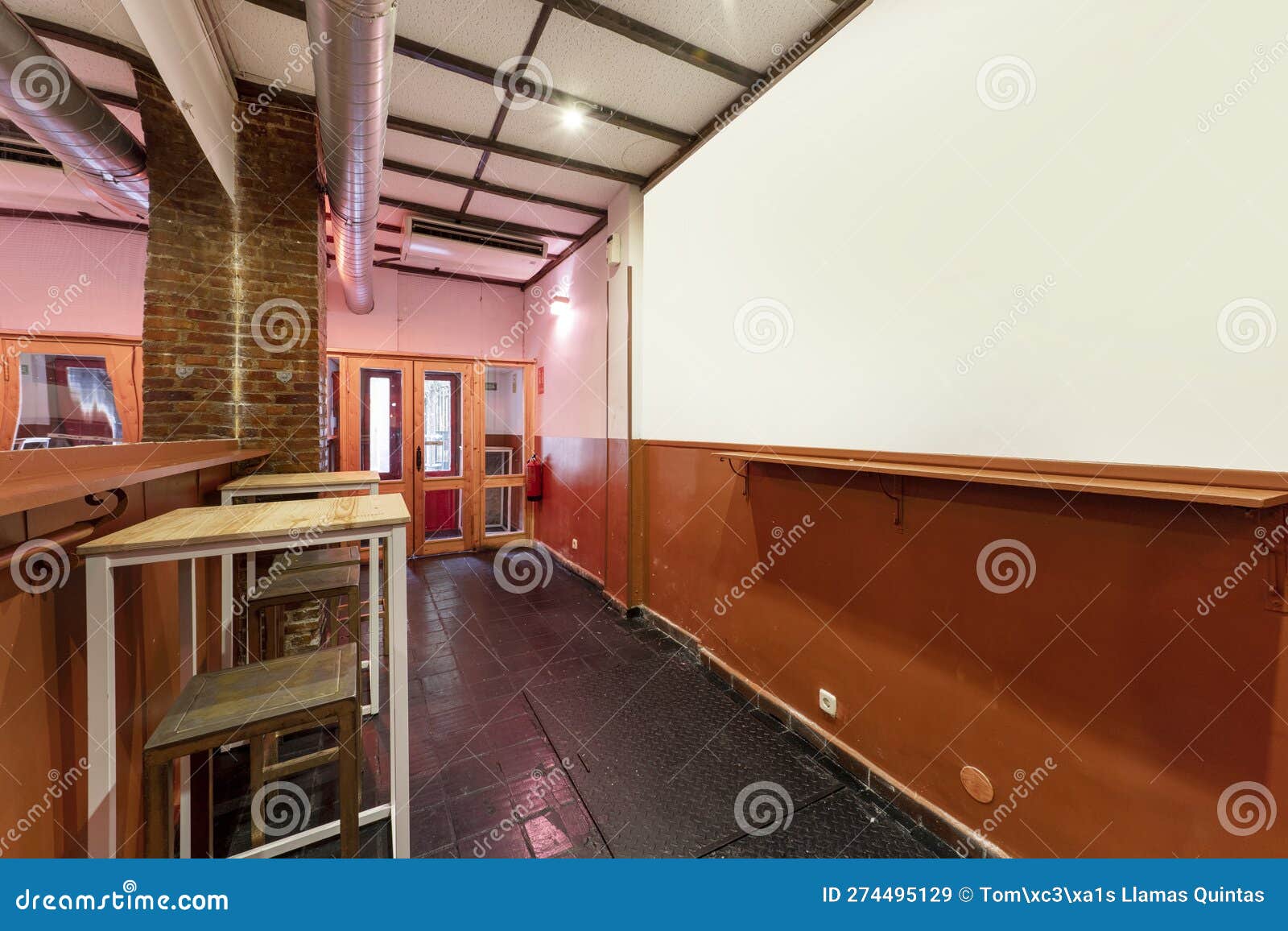 a cheaply built bar with high tables and matching stools with